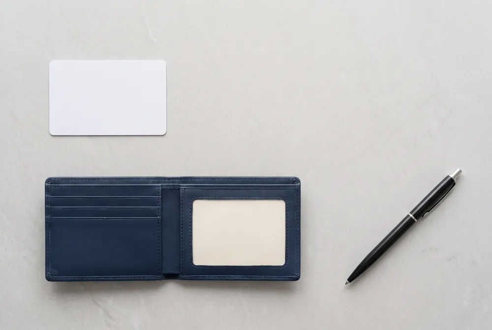 Blank plastic card, wallet and pen on a counter